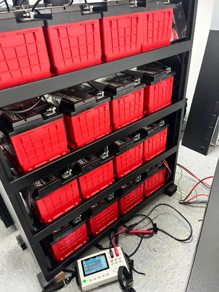Análise de resistência interna em banco de baterias estacionárias Freedom utilizando analisador digital com cabos conectados aos polos, realizando teste de diagnóstico e saúde em sistema de energia para nobreak corporativo.